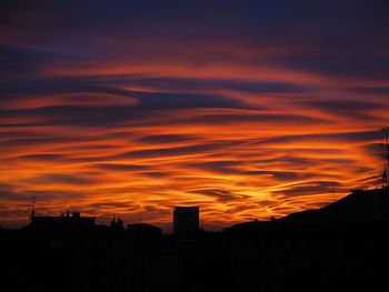 Silhouette cityscape against sky during sunset