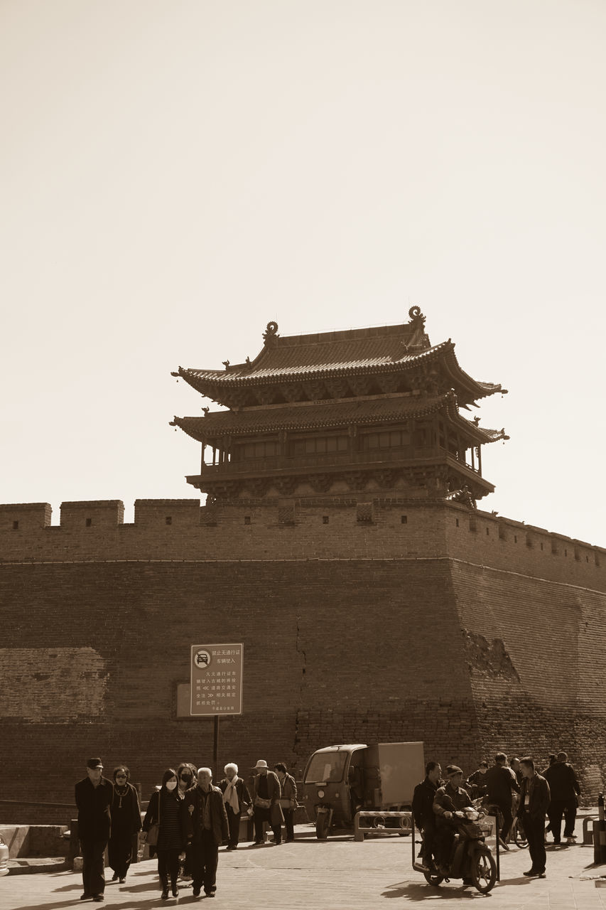 GROUP OF PEOPLE IN FRONT OF BUILT STRUCTURE