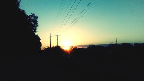 Silhouette trees against sky during sunset