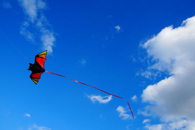 Low angle view of creative kite flying in blue sky