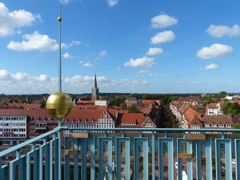 Buildings in town against cloudy sky