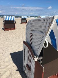 Chairs on beach against sky on sunny day
