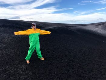 Full length of woman standing on sand against sky