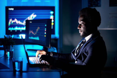 African american employee typing on laptop in workspace