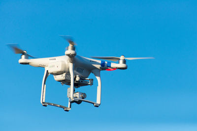 Quadcopter flying in clear blue sky