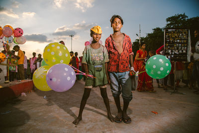 Group of people with balloons standing against the sky