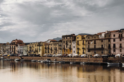 Buildings by river against sky in city of bosa, sardinia, italy