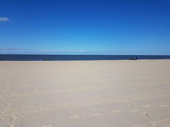 Scenic view of beach against clear blue sky