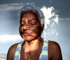 Close-up of senior woman against wall