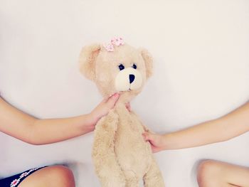 Midsection of woman with toy against white background