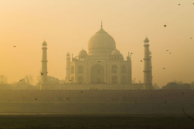 Taj mahal against clear sky in foggy weather during sunset