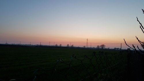 Scenic view of field against clear sky during sunset