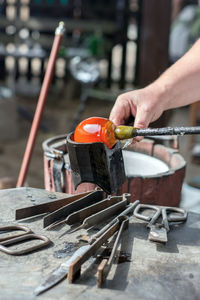 Close-up of man holding glass and rod