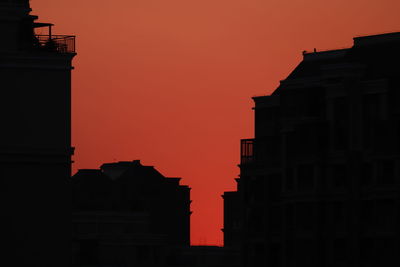 Low angle view of silhouette buildings against sky during sunset