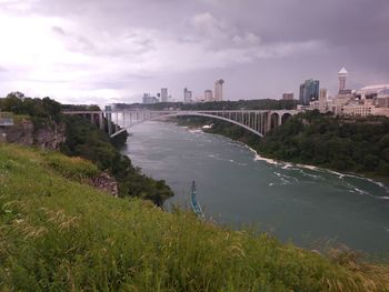 Scenic view of river by buildings against sky