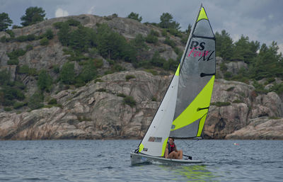 Boat in sea against mountain