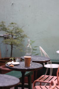 Bottle and disposable cup on table at restaurant