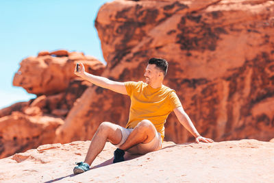 Portrait of young man sitting on rock