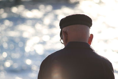 Rear view of senior man standing in front of sea