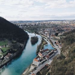 High angle view of river amidst buildings in city against sky