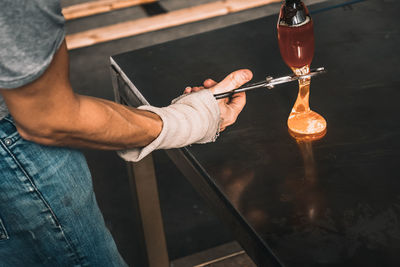 Cropped image of worker cutting glass in factory
