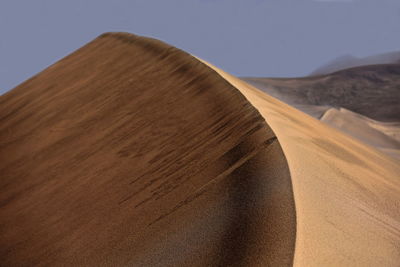 Sand dunes in desert against sky