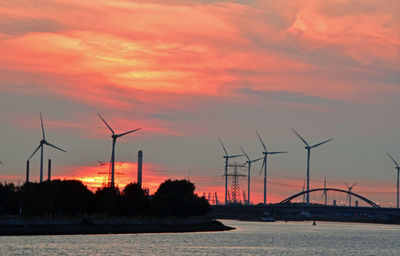 Silhouette of wind turbine against sky during sunset