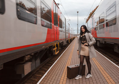 Full length of young woman on train at railroad station