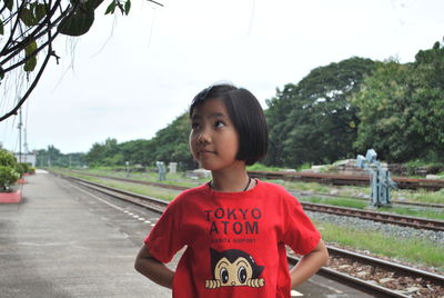 Cute girl standing on railroad station platform