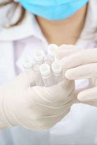 Midsection of scientist holding test tubes at laboratory