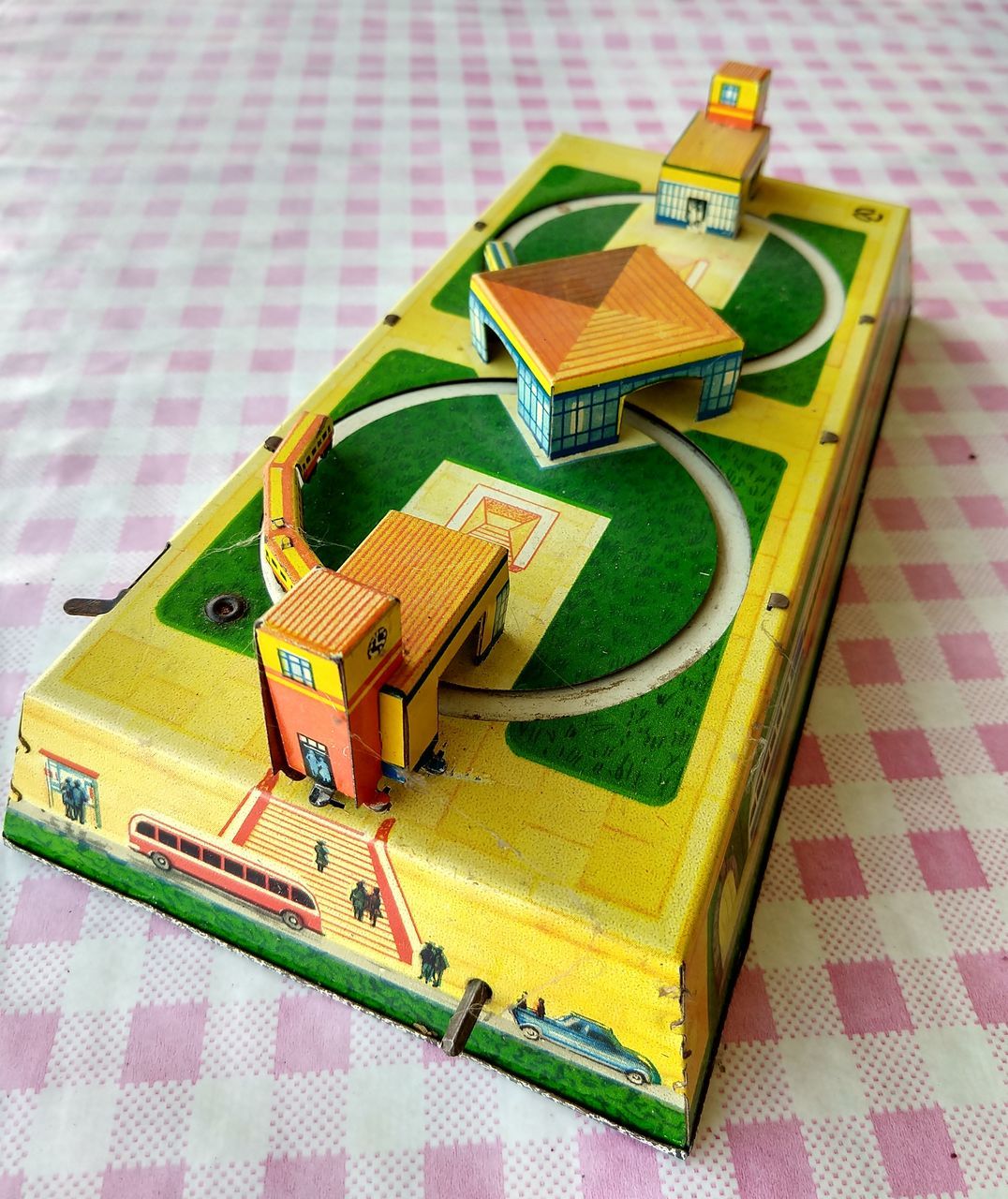 still life, green color, no people, table, indoors, multi colored, high angle view, close-up, pattern, toy, tablecloth, toy car, wood - material, creativity, yellow, focus on foreground, art and craft, car, day, stack, floral pattern