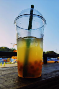 Close-up of drink on table against sky