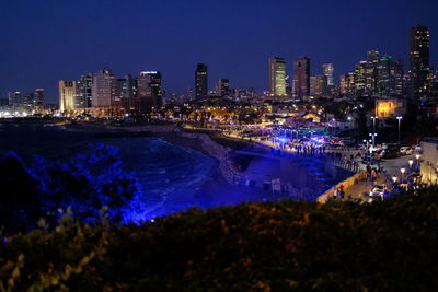 High angle view of illuminated buildings in city at night