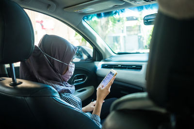 Midsection of woman sitting in car