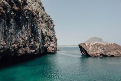 Scenic view of rock formation in sea against clear sky