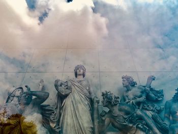 Low angle view of statues on building against sky