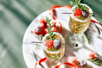 Christmas cocktail with sparkling wine, rosemary and cherry. winter holidays champagne drink.