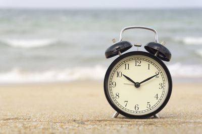 Close-up of clock on the beach