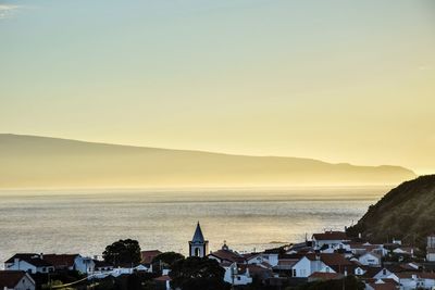 High angle view of townscape by sea against sky