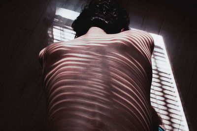 Rear view of man lying at home
