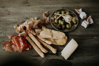 Ham, cheese, olives, and bread on table