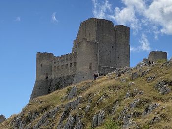 Low angle view of old ruin building against blue sky