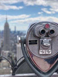 Close-up of coin-operated binoculars against sky