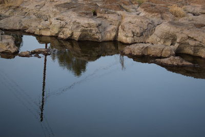 Reflection of rock formation in lake against sky