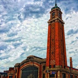 Low angle view of clock tower against cloudy sky