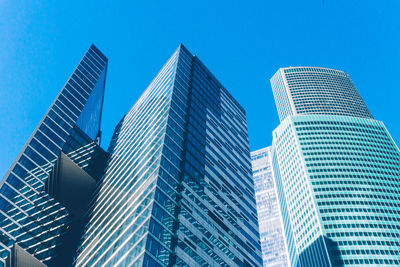 Low angle view of modern buildings against clear blue sky