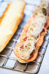 High angle view of onion and tomato slices on baguette at table