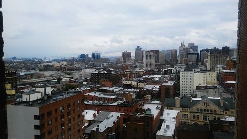 Cityscape against cloudy sky