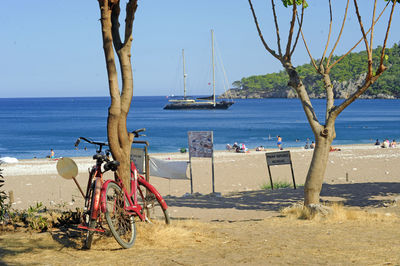 Bicycles on beach against clear sky