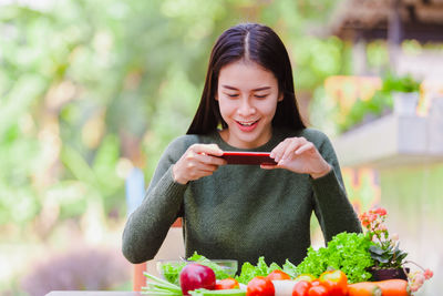 Young woman holding mobile phone outdoors